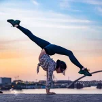 esnek kızlık zarı yazısına ait foto, gün batımında akrobatik hareket yapan esnek genç kadın